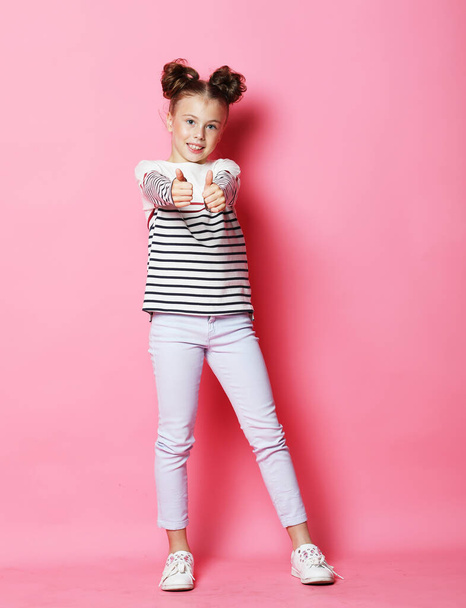 Cute little girl dressed casually posing on pink background - Fotó, kép