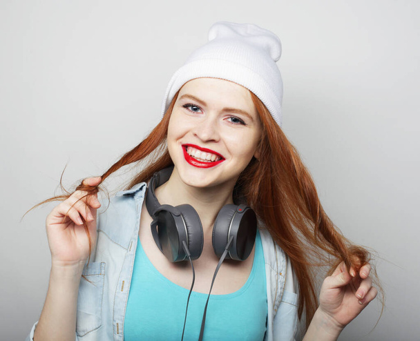 charming hipster girl with headphones and white hat smiles and laughs - Photo, image