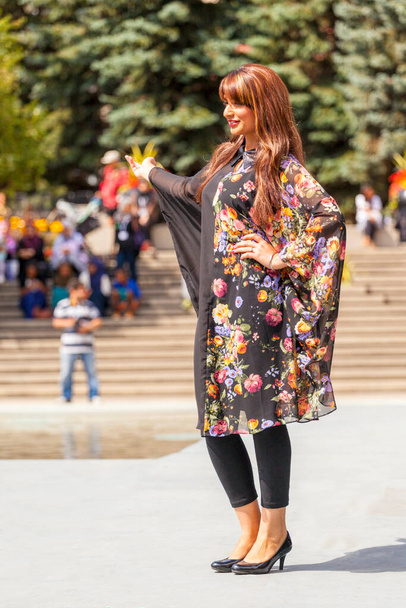 Calgary, Kanada - Sierpień 10, 2014: Modelka przedstawiająca modę arabskiego stylu w miejscu publicznym na Olympic Plaza.  - Zdjęcie, obraz