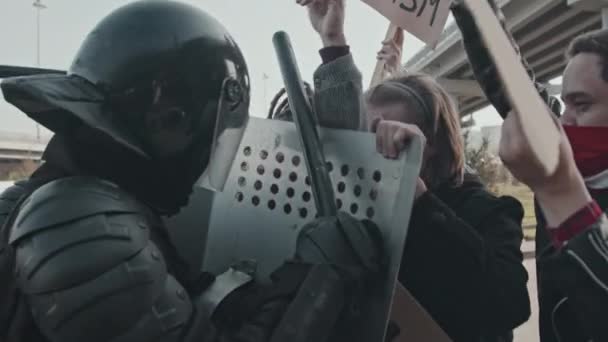 Langzaam schot van demonstranten met borden tegen oproerpolitie schilden - Video