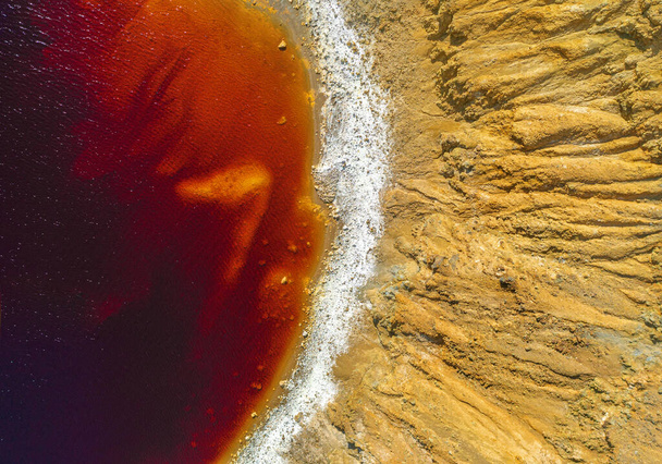 Shore of toxic red lake in abandoned open pit copper mine. Its unusual color is the result of the pyrite ore extraction in the area - Photo, Image