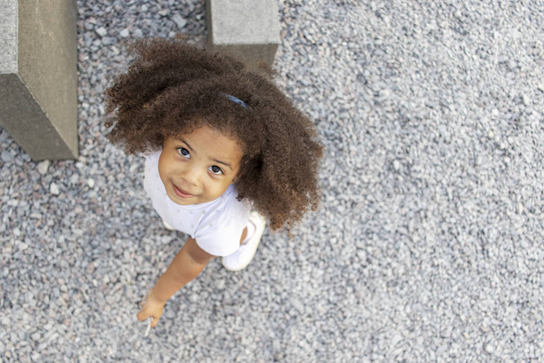 Retrato al aire libre de una chica afroamericana rizada. Vista de ángulo alto. - Foto, Imagen