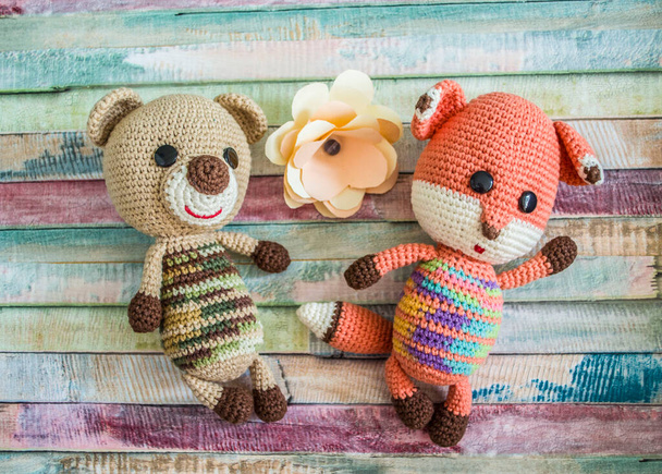 Crocheted teddy bear and chanterelle on a wooden background. Handmade toy. - Fotoğraf, Görsel