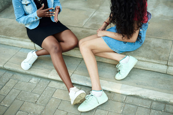 Ноги двух молодых женщин. разговор подружек на улице, концепция. Без лица - Фото, изображение