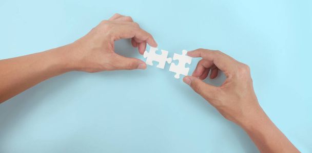 Holds in hand  jigsaw puzzle. Business solutions success and strategy concept - Фото, изображение