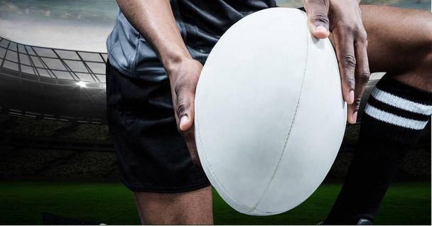 Composition of male rugby player holding rugby ball at stadium. sport and competition concept digitally generated image. - Foto, Imagem