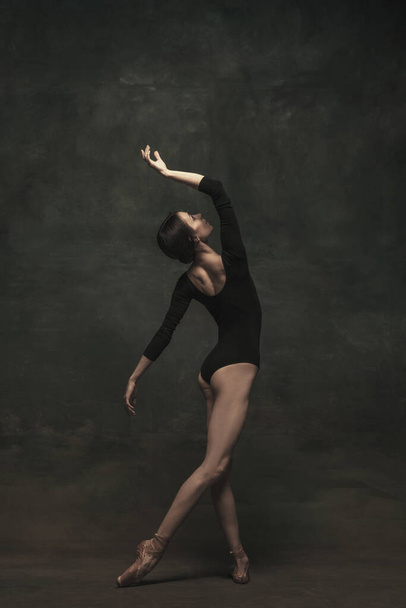 Joven y elegante bailarina de ballet aislada sobre fondo oscuro. Arte, movimiento, acción, flexibilidad, concepto de inspiración. - Foto, imagen