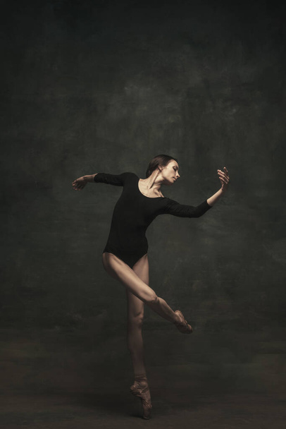 Young and graceful ballet dancer isolated on dark background. Art, motion, action, flexibility, inspiration concept. - Fotografie, Obrázek