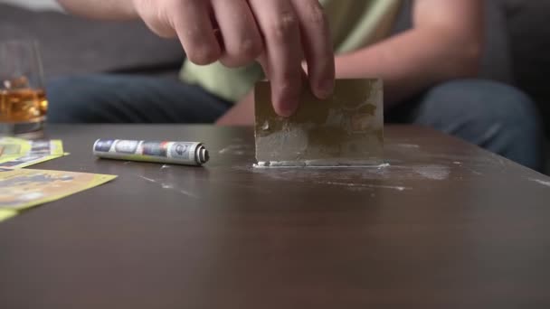 Nuori kaveri käyttää huumeita ja istuu sohvalla, huumeiden ja alkoholin haittojen käsite, huoleton elämä - Materiaali, video