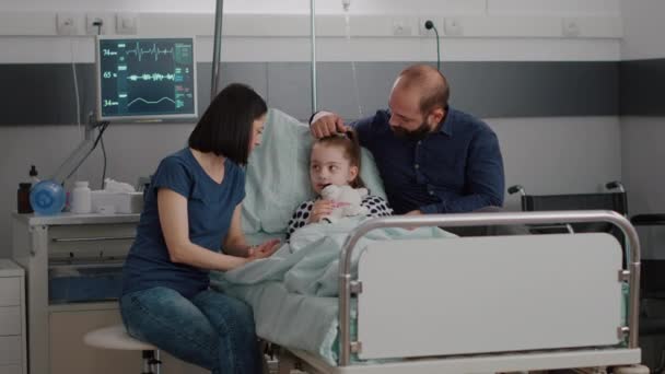 Οικογένεια κάθεται δίπλα νοσηλεύεται άρρωστη κόρη συζητώντας φαρμακευτική αγωγή θεραπεία αποκατάστασης - Πλάνα, βίντεο