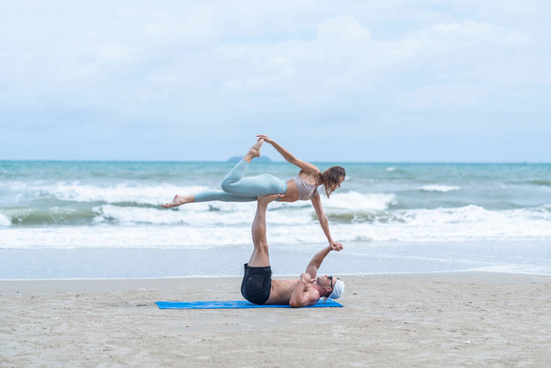 Молодые пары стоят взад и вперед после тренировки вместе на пляже  - Фото, изображение