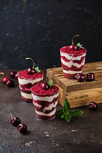 Trifle veludo vermelho com creme de queijo creme e géis de cereja. Sobremesa decorada com cerejas frescas e hortelã. - Foto, Imagem