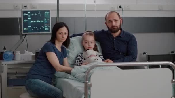 Πορτρέτο της λυπημένης οικογένειας κοιτάζοντας στην κάμερα, ενώ κρατώντας άρρωστα χέρια κόρη - Πλάνα, βίντεο