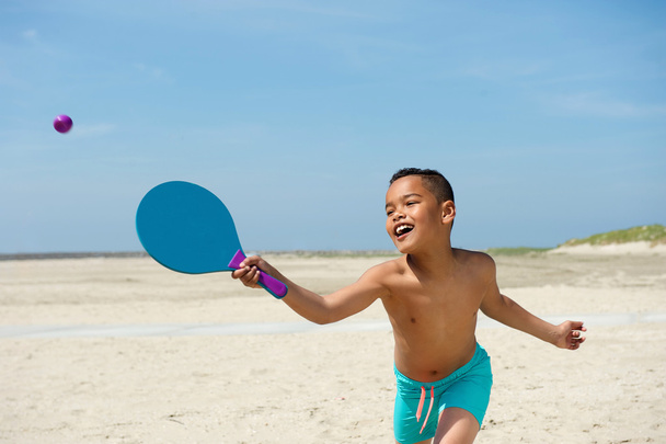 Ativo menino brincando na praia
 - Foto, Imagem