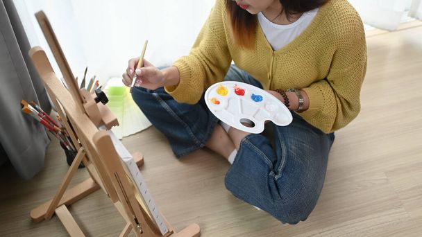 Przycięte ujęcie młodej artystki malującej w domu kreatywnie trzymającej paletę. - Zdjęcie, obraz