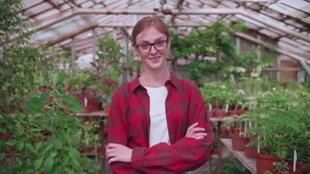 Portrét mladého pracovníka ve skleníku, ve kterém rostou květiny a rostliny, dívčí inspektor - Záběry, video
