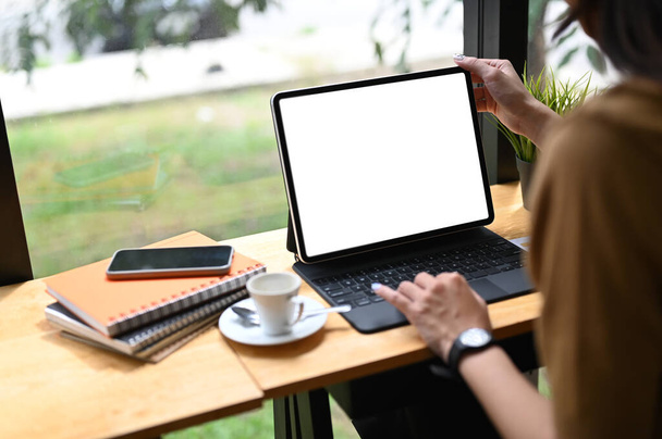 Captura recortada de un trabajador de oficina usando una tableta de computadora con pantalla blanca en la oficina. - Foto, imagen