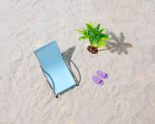 Sdraio sulla spiaggia sabbiosa per prendere il sole accanto a una palma. Composizione estiva. - Foto, immagini