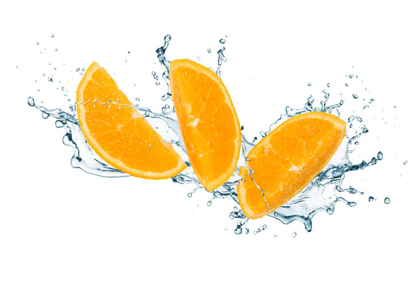 Fruto naranja rebanado con agua salpicada aislada sobre fondo blanco - Foto, Imagen