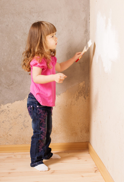 little child with paintbrush on background old wall - 写真・画像