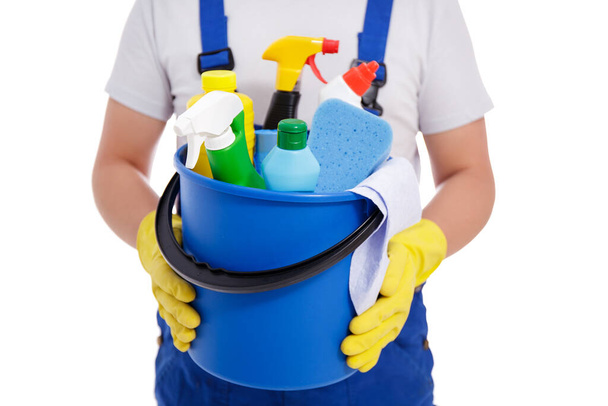 Mavi üniformalı erkek temizlikçi ve sarı eldivenli kovayla temizlik ekipmanları beyaz arka planda izole edilmiş. - Fotoğraf, Görsel