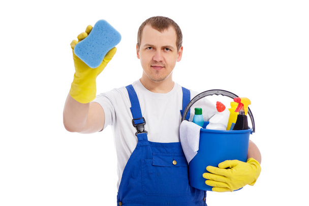 portret van professionele mannelijke reiniger in blauw uniform emmer met reinigingsapparatuur en reinigingsvenster geïsoleerd op witte achtergrond - Foto, afbeelding