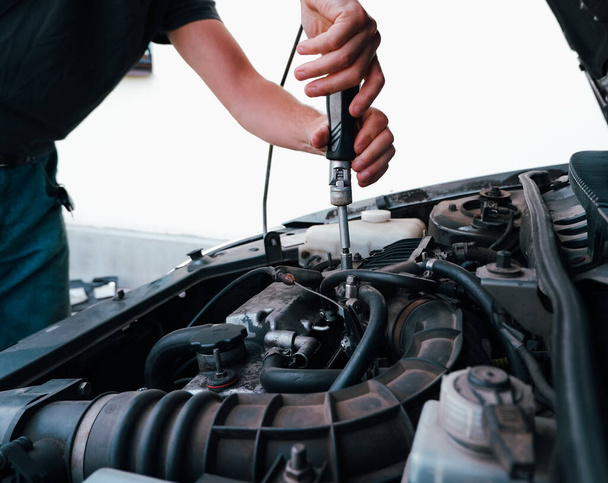 Car repair. Auto mechanic working on car engine in mechanics garage. Repair service. Close up of car mechanic repairer technician repairs auto engine - Photo, Image