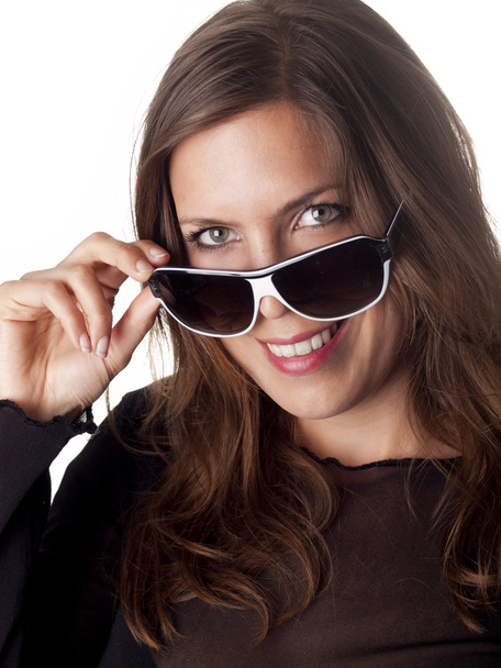 Bella bruna sorridente guardando sopra i suoi occhiali da sole
 - Foto, immagini