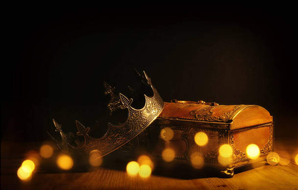 low key image of beautiful queen or king crown over gold treasure chest. vintage filtered. fantasy medieval period - Foto, imagen