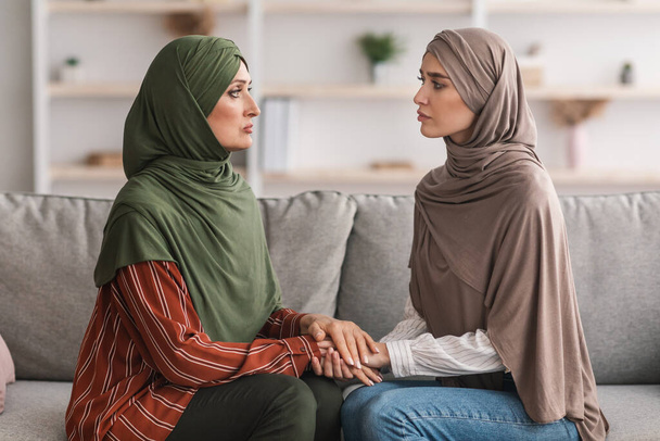 Unhappy Mature Muslim Mother And Adult Daughter Holding Hands Indoor - Photo, Image