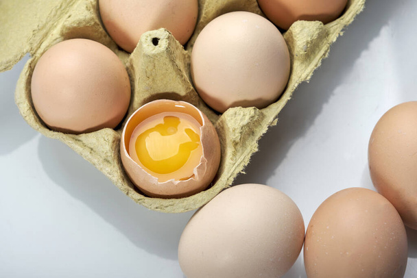 Detailní záběr vajec v karikatuře na bílém pozadí. Syrové kuřecí vejce v krabici s vejci organické potraviny pro dobré zdraví s vysokým obsahem bílkovin . - Fotografie, Obrázek