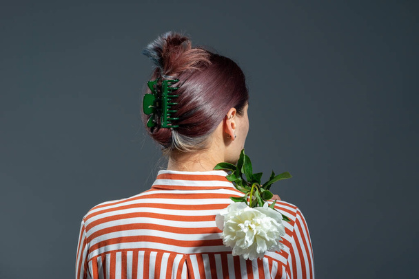 fashionable green hairpin in the hair of a girl on a gray background. - Photo, Image