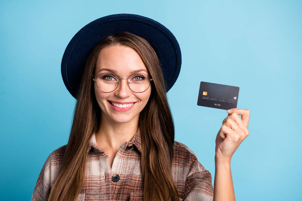 Portrait of young attractive lovely pretty smiling cheerful good mood girl showing credit card isolated on blue color background - Fotografie, Obrázek