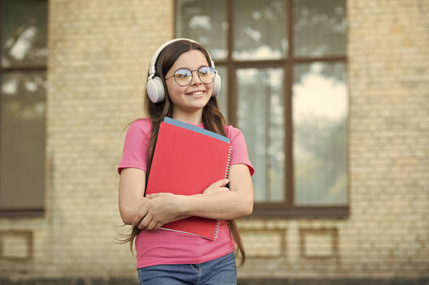 Girls deserve the world. get knowledge from ebook. modern school education. back to school. happy teen carry workbook. smiling kid hold folders. childhood happiness. girl in headset listen music - Foto, afbeelding