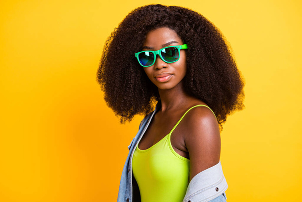 Photo of cute confident dark skin lady dressed denim outfit glasses isolated yellow color background - Foto, immagini