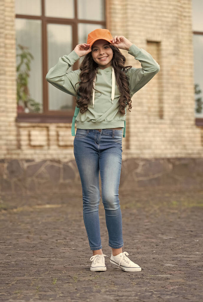 Happy girl fix stylish cap with fashion look wearing casual clothes on urban outdoors, hipster - Zdjęcie, obraz