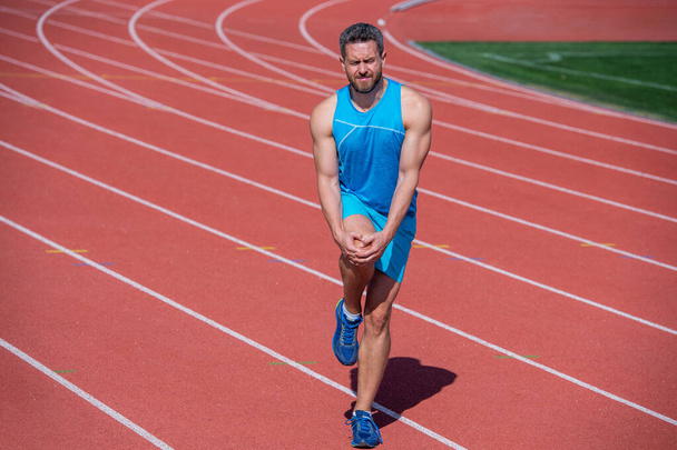 male runner flex muscles because of sport trauma after workout, sport injury - Foto, Bild