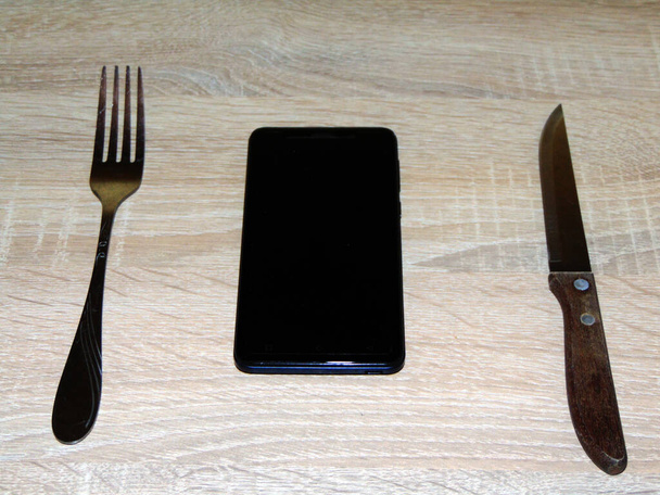 Bıçak, çatal ve masada akıllı telefon - akıllı telefon bağımlılığı konsepti - Fotoğraf, Görsel