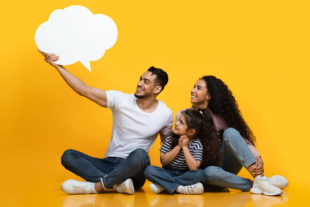 Cheerful Middle Eastern Family Of Three Looking At Empty Speech Bubble - Фото, изображение