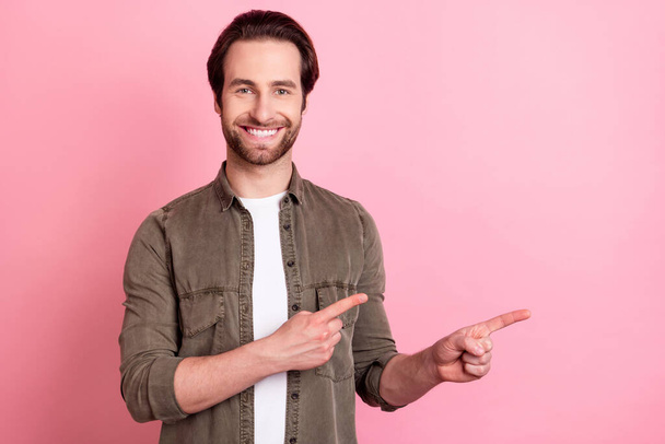 Photo of young man happy positive smile indicate fingers empty space advert advice choice decision isolated over pink color background - Photo, image