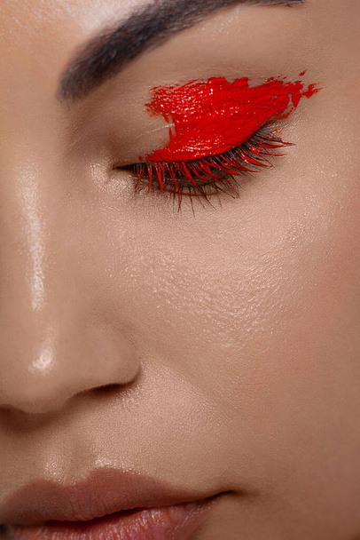 Beauty close-up portrait of beautiful young woman model face with clean skin. Wellness, skincare and bright black liner and red make-up. extremaly long eyelashes - Photo, image