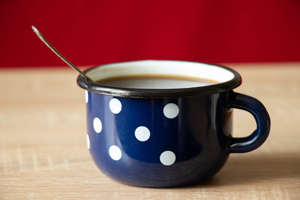 голубая чашка с белым горохом на старом деревянном столе, чашка с кофе по утрам - Фото, изображение