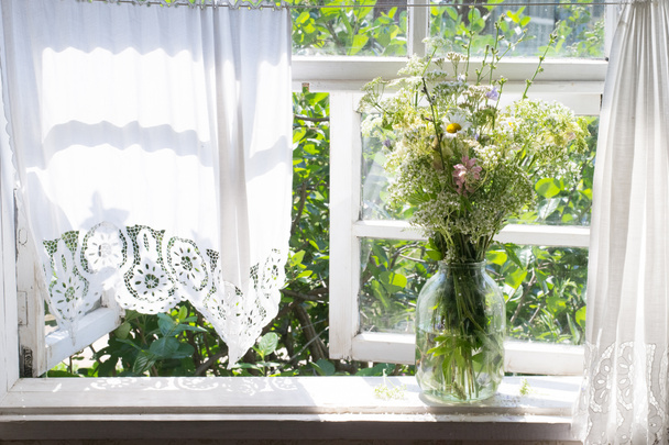 窓辺に野生の花の花束。田舎の家の窓 - 写真・画像