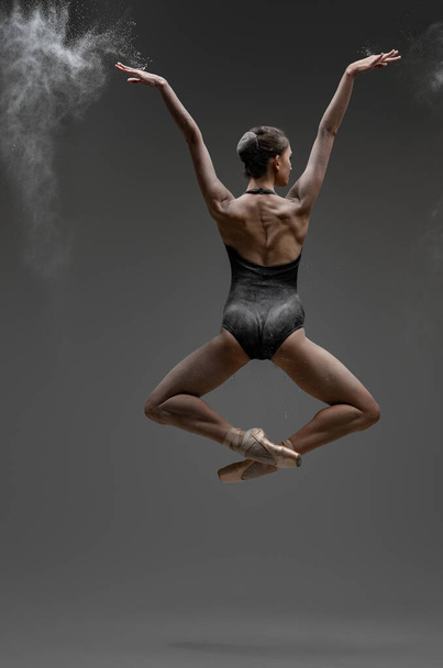 Backview colpo di saltare ballerina con le braccia tese - Foto, immagini