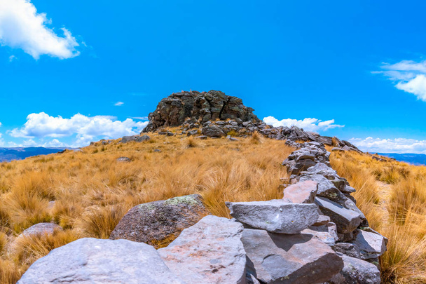 A stone fence against the blue sky captured on a sunny autumn day in the Sierra del Peru - Фото, изображение