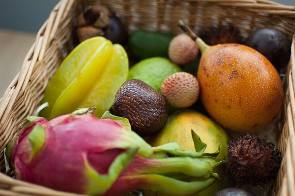 Μεγάλο καλάθι με φρέσκα τροπικά φρούτα, φρούτα του πάθους, καραμπόλα, φρούτα του δράκου ή pitaya, mangosteen, lichi, granadilla. Εξωτικά φρούτα, έννοια υγιεινής διατροφής - Φωτογραφία, εικόνα