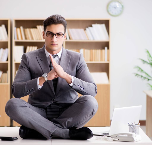 młody biznesmen medytujący w biurze - Zdjęcie, obraz