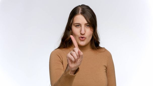 Το πορτραίτο μιας νεαρής γυναίκας να κουνάει το μανίκι της και να λέει όχι. Έννοια της απαγόρευσης, της απαγόρευσης και του ταμπού - Φωτογραφία, εικόνα