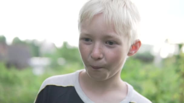 Primer plano de la cara de un hermoso chico rubio verano al aire libre - Metraje, vídeo