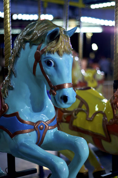 Azul brillante Caballo en carrusel alegre dar la vuelta en carnaval en la noche, de cerca. - Foto, imagen